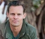 Close-up portrait of a man wearing a casual jacket outdoors.